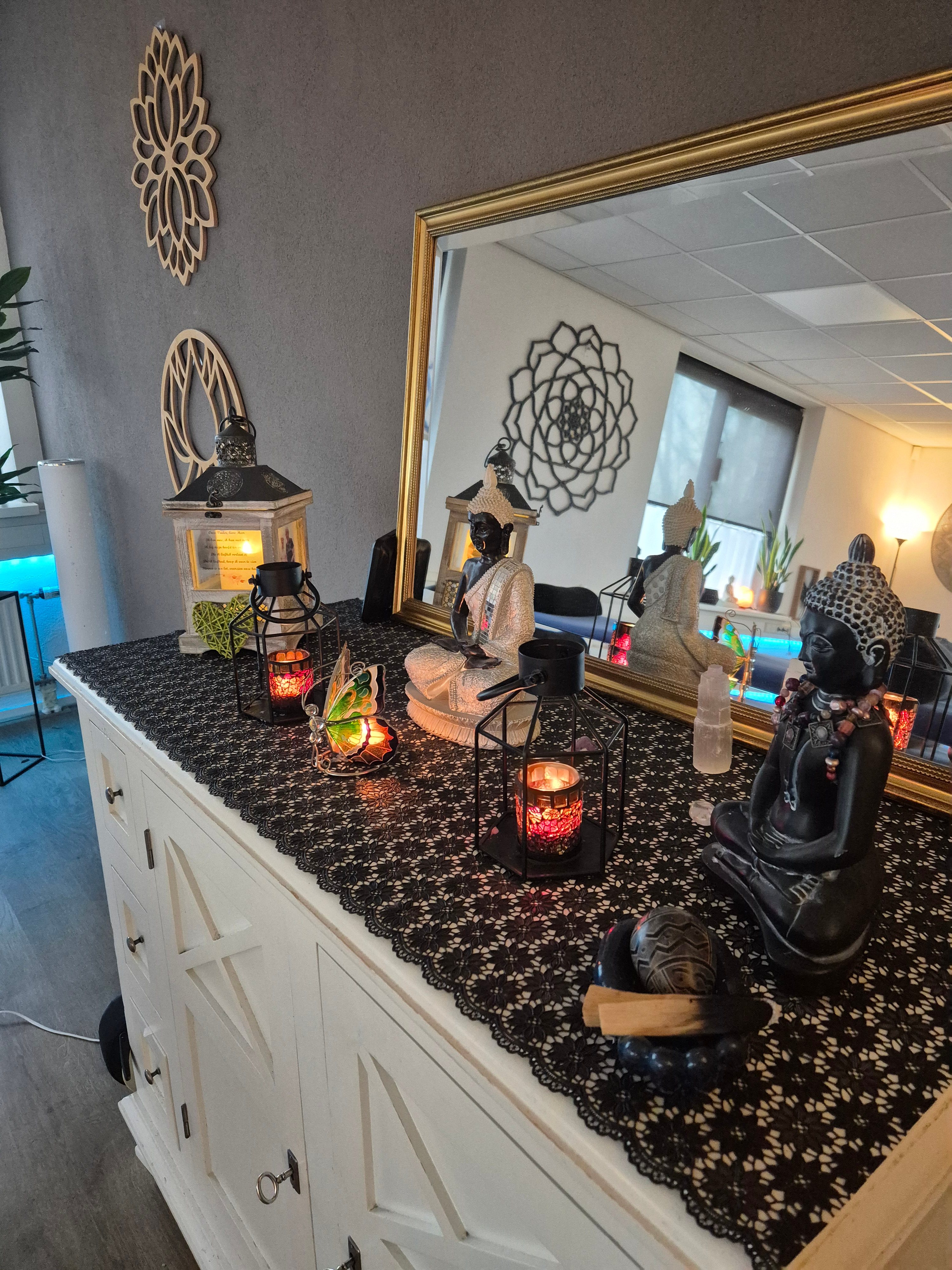 Altaar met Boeddha beelden, kaarsen en spiegel